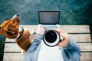 Managing remote workers, Man works remotely from park on laptop and coffee